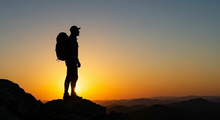 Hiker silhouette at sunset on mountain peak.