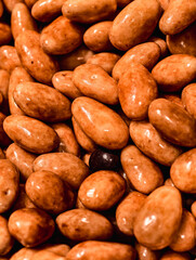 Glazed Caramel Almonds. Macro Photography of Glossy Candied Nuts. Gourmet Party Snacks and Festive Confectionery Treats in Rich Brown Detail