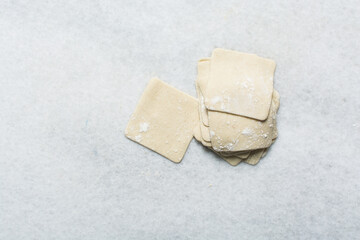 Overhead view of dumpling wrappers dough being cut, process of making wonton skins, process of making homemade dumplings