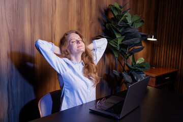 Relaxed businesswoman taking a break at work, leaning back with eyes closed, enjoying relief after work, office atmosphere.