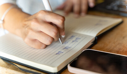 Handwriting Notes in a Journal with Smartphone Nearby