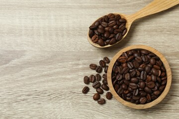 Coffee beans in a spoon on wooden background