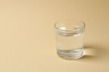 Glass of water on color background