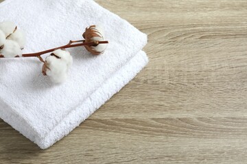 Stack of white towels and cotton flowers on the table