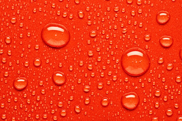 Water droplets on vibrant red surface creating textured art