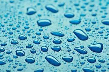 Close up of blue water droplets on a textured surface