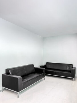 Minimalist waiting room with black leather sofas