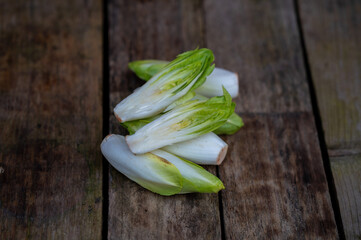 Raw organic Belgian endive ready to use on wooden table