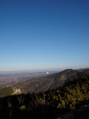 Fototapeta premium Breathtaking Mountain Summit View Showcasing Steep Forested Slopes and Vast Landscape Beyond