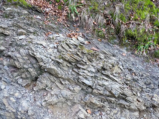 Close-up of Layered Rock Formation with Moss Growing on Surface in Natural Environment