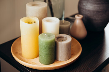 A set of colored candles on a table in a living room interior.