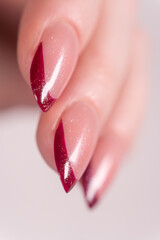 French manicure with bold red tips and a shimmering finish, making the nails stand out with vibrancy and expressiveness. These tips have a glossy, shimmering finish, adding a touch of sparkle.