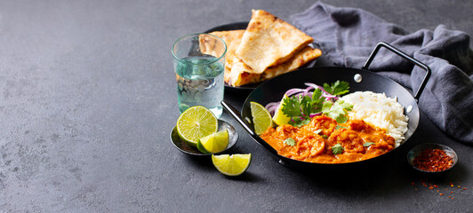 Kerala prawns curry in black bowl. Grey background. Copy space.