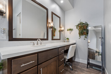 A spacious bathroom that features two sinks, two mirrors, and a desk