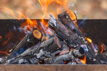 A stack of firewood burning on a barbecue