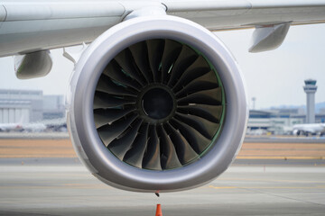 Close-up of jet engine turbine at airport runway