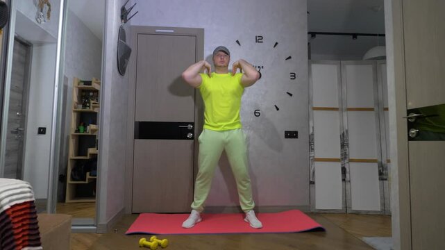 Warm up the shoulder joint during training at home. Men's workout on a fitness mat. Slow motion