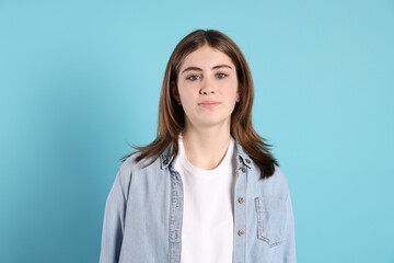 Obraz premium Portrait of beautiful teenage girl on light blue background
