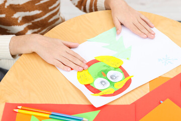 Girl making art project at table indoors, closeup