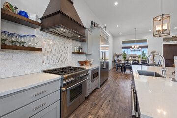 Fototapeta premium A spacious kitchen featuring a large island and nicely designed wooden chairs