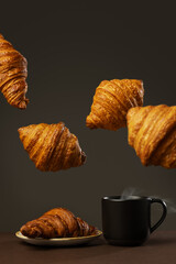 Many croissants flying and a cup of coffee