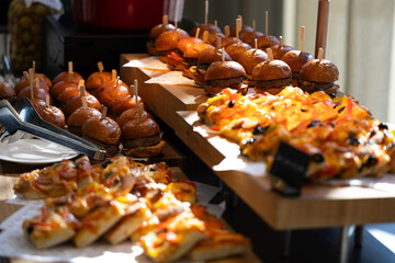 Lunch time on a big event, buffet with mini burgers and pizza
