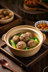 there is a bowl of soup with meatballs and vegetables on a tray