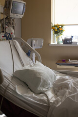 Cama blanca de paciente en habitación de hospital 