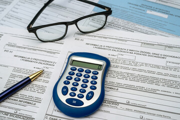 Polish PIT 11 37 38 tax form prepared to be filled with pen calculator glasses on desk