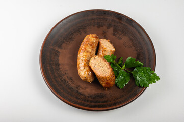 Homemade grilled sausage on a rustic ceramic plate with fresh parsley garnish. Traditional dish with crispy golden crust and juicy filling. Delicious food photography