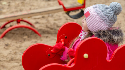 Little girl having fun on playground. Happy healthy little child climbing, swinging and sliding on...