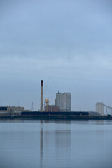 Lonely Industrial Building Under Cloudy Sky with Water Reflection