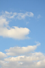 Fototapeta premium Vertical blue sky with white clouds background in sunny day. 