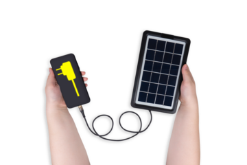 Portable solar panel in one hand connected to smartphone in other hand on transparent background (close-up). Smartphone screen shows electric plug icon. Alternative energy concept