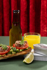 Tuna sandwiches on a table next to lemonade and beer, in a modern interior design