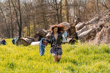 beautiful smiling red-haired woman running in a grassy field with watercolor paint kit