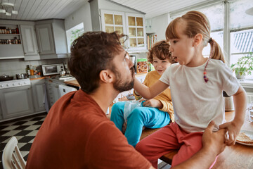 Fototapeta premium Single father having breakfast with his kids in the morning in the kitchen