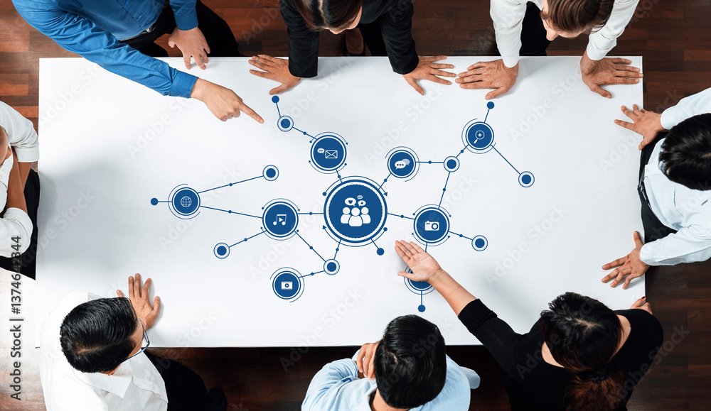 Fototapete A top view of a business meeting where team members collaborate on a media strategy. Various digital content icons connect, highlighting effective communication and teamwork. Amity