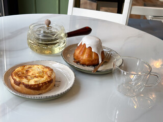 Pastry tart and glazed cake served with herbal tea on a cafe table. Cozy break and slow lifestyle...
