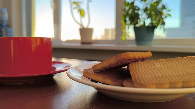 red cup with a plate of cookies on the office table at sunrise