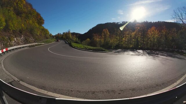 Single red car driving on an S-shaped mountain road in the Schw&auml;bische Alb National Park
