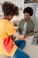 Joyful African Mother and Daughter Cooking Together in Bright Modern Kitchen