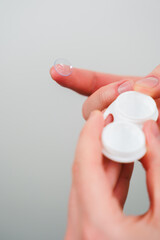 Eyesight correction with optical lens. Closeup contact lens for vision correction in hands.