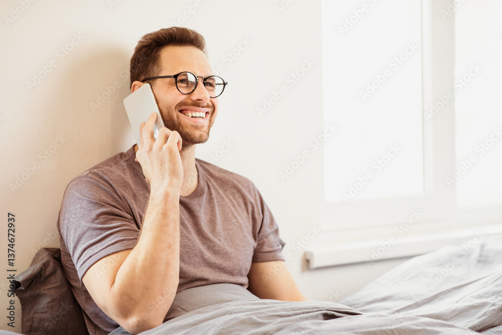 Poster guy talking on cellphone calling having phone conversation sitting in bed at home. man speaking on s