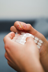 Cosmetic acne patches for pimple and rosacea treatment. Closeup of hands hold acne patches for skin...
