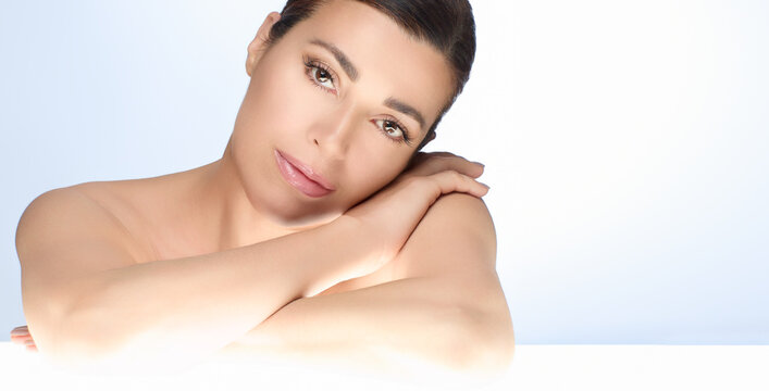 Gorgeous natural woman with flawless skin, showcasing beauty and skincare concept, isolated on a light background with copy space, gentle pose highlighting healthy skin and serene expression