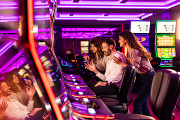 Group of Friends Enjoying Slot Machines in a Neon Casino Environment