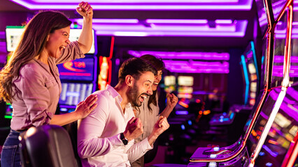Excited Friends Celebrating a Win at a Casino Slot Machine