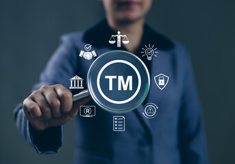 TM, Trademark Protection, Intellectual Property Concept. Person holding magnifying glass with 