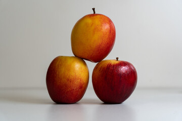 3 apples stacked to make a pyramid on a white background
